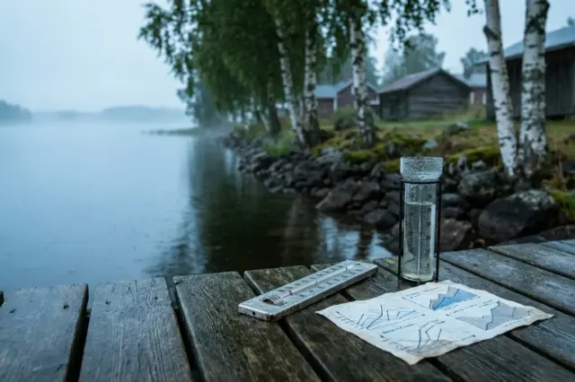 Kuvituskuva kymmenen vuorokauden ennusteeseen: järvimaisema, mittari ja abstraktit käyrät.